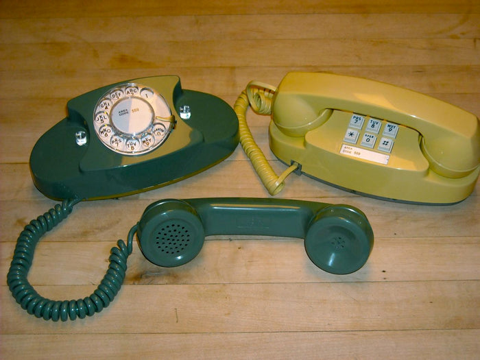 A group of Western Electric Princess telephones in several colors, showing the compact oval base and center dial.