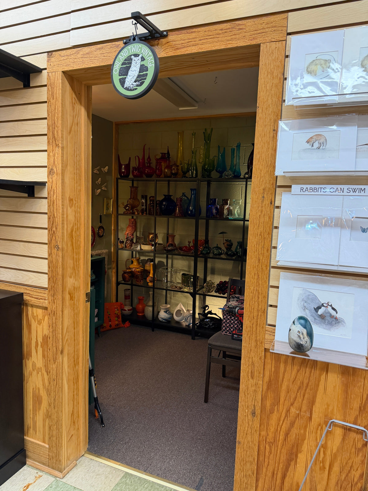 Doorway into the Owl and Twig Vintage booth at The Rabbit Hole in Waterford, Michigan, under a hand-painted owl sign