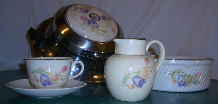 A Hall China waffle iron, batter bowl, syrup pitcher, and coffee cup and saucer in the company's single-fire glaze