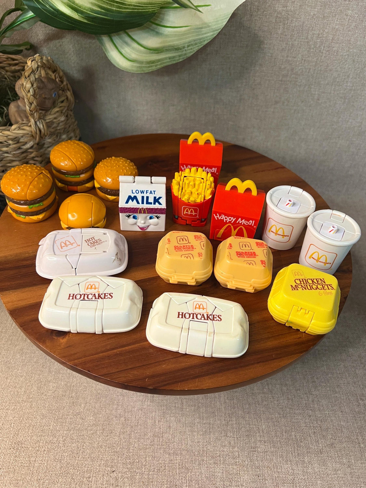 A lot of McDonald's Changeables Happy Meal toys in food mode on a wooden tray