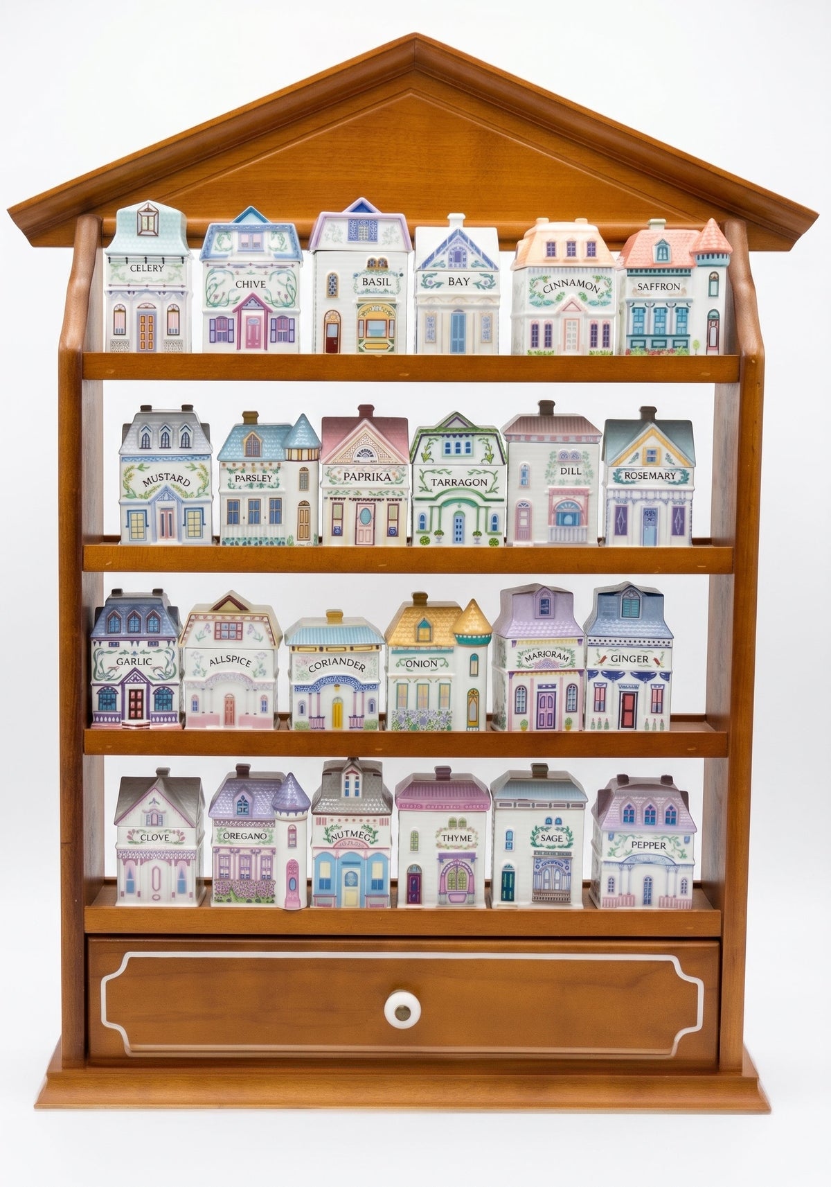 A complete 24-piece Lenox Spice Village set displayed in its original house-shaped wooden rack, four shelves of six pastel porcelain spice houses with a drawer at the base