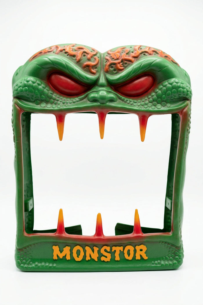 Green Monstor vending machine shell with red eyes and yellow fangs