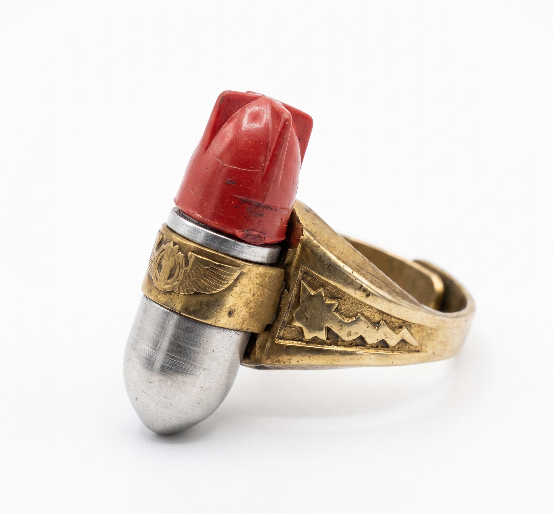 A vintage Kix Atomic Bomb Ring, showing the gold-toned band and aluminum warhead with its removable red plastic tailfin.