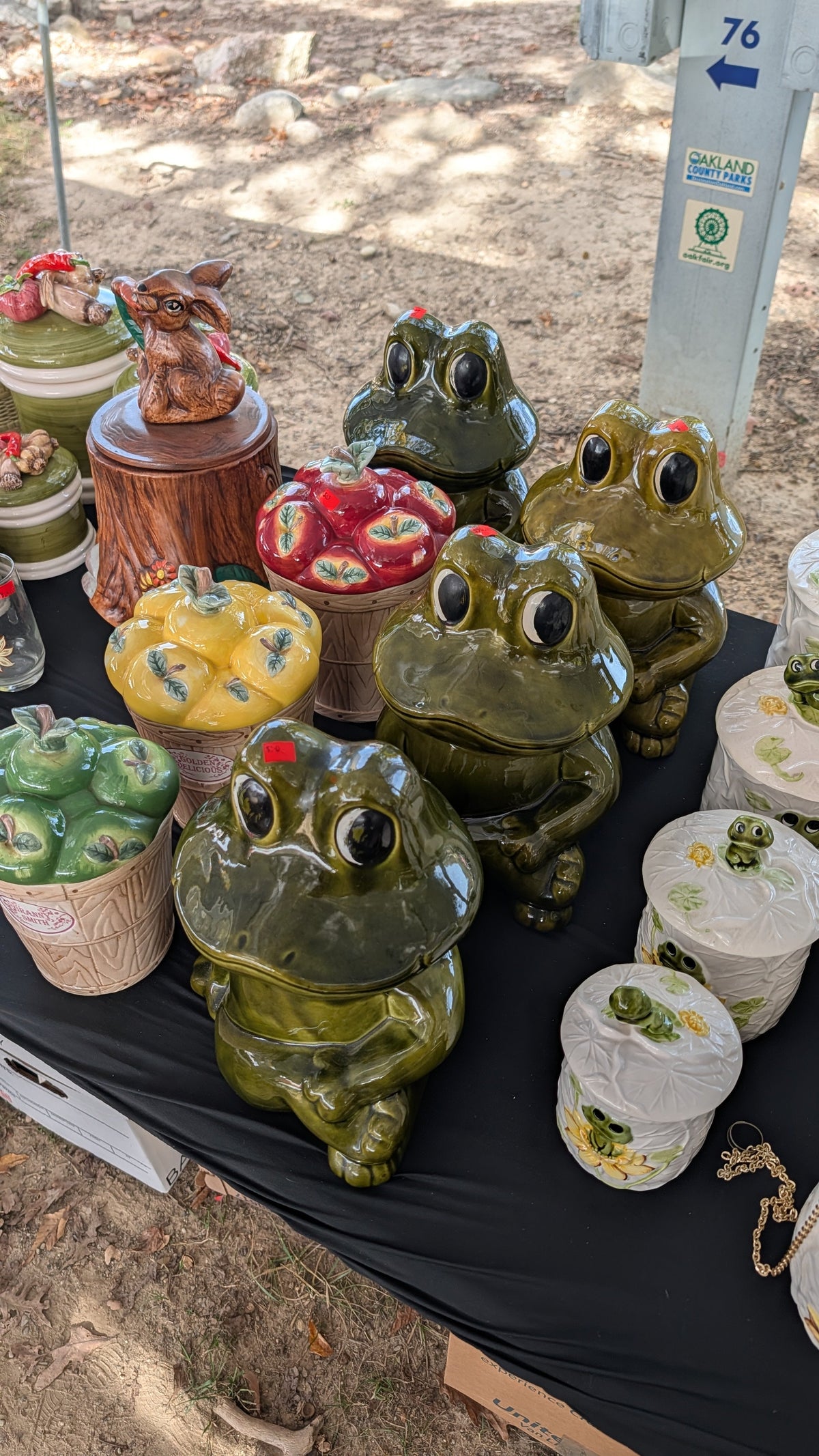 Four green figural frog cookie jars on a flea market table in Oakland County, Michigan